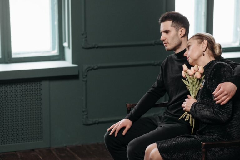 A mother and son sharing a quiet, emotional moment with tulip flowers indoors.